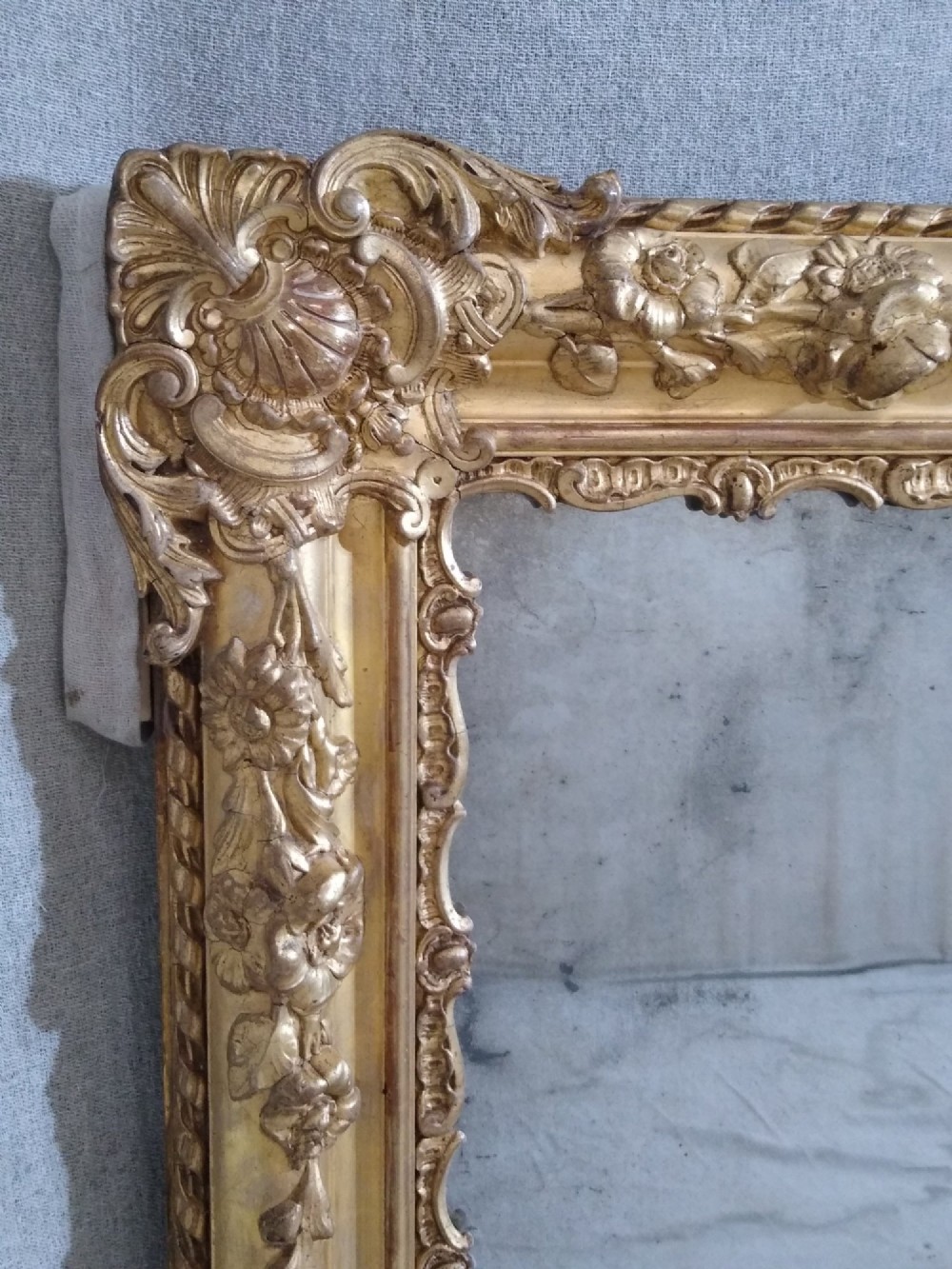 A large rectangular 19th-century French overmantel mirror featuring an ornate gold giltwood frame with detailed foliate and floral moulding. View VIII