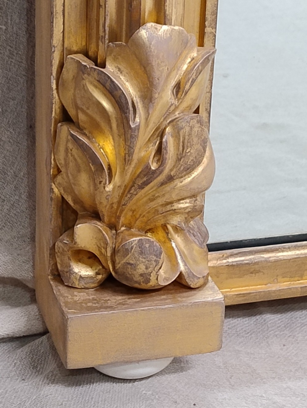 A large nineteenth-century giltwood overmantel mirror featuring carved acanthus leaf cresting and fluted column pilasters. View II