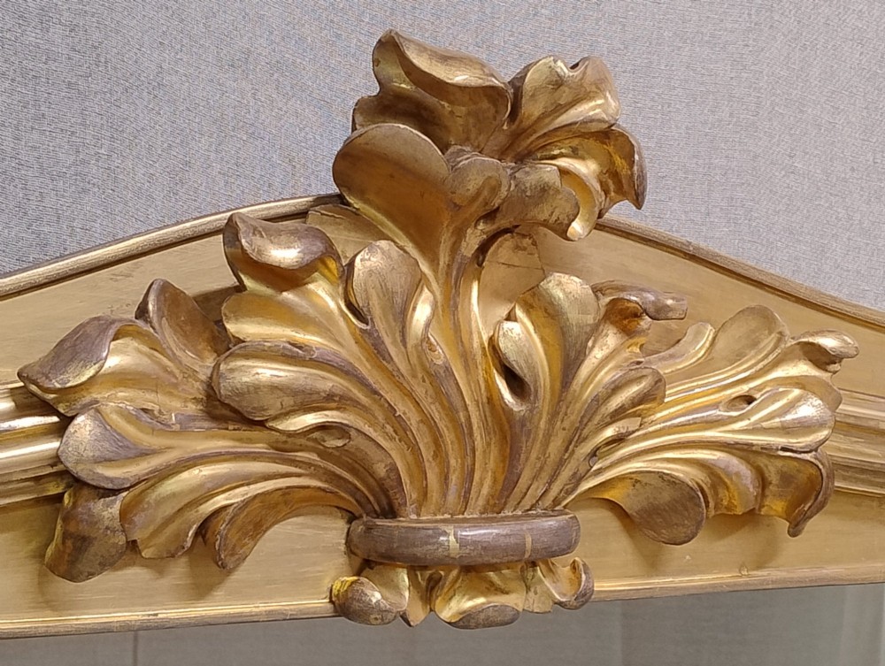 A large nineteenth-century giltwood overmantel mirror featuring carved acanthus leaf cresting and fluted column pilasters. View IV