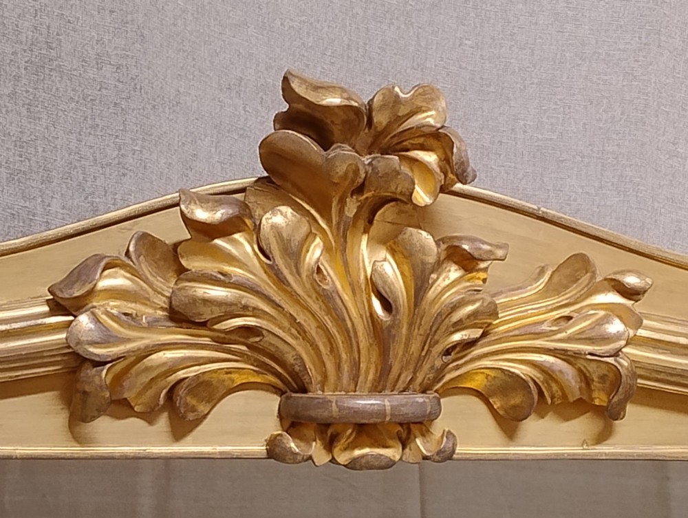 A large nineteenth-century giltwood overmantel mirror featuring carved acanthus leaf cresting and fluted column pilasters. View VII