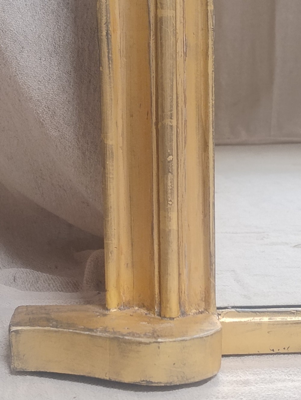 An antique Victorian arched overmantel mirror featuring a moulded gold giltwood frame with subtle bottom side corbels. View II