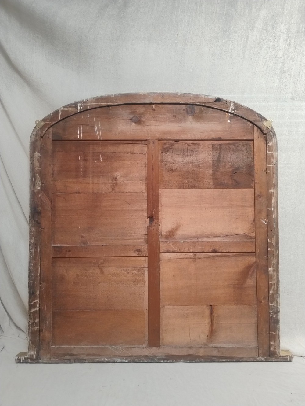 An antique Victorian arched overmantel mirror featuring a moulded gold giltwood frame with subtle bottom side corbels. View VII
