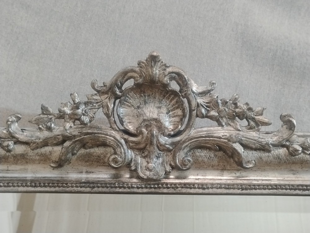 A large nineteenth-century French wall mirror featuring a silver gilt wooden frame, rounded top corners, beaded inner border, and an ornate carved shell crest. View IV