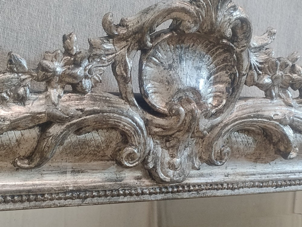 A large nineteenth-century French wall mirror featuring a silver gilt wooden frame, rounded top corners, beaded inner border, and an ornate carved shell crest. View V