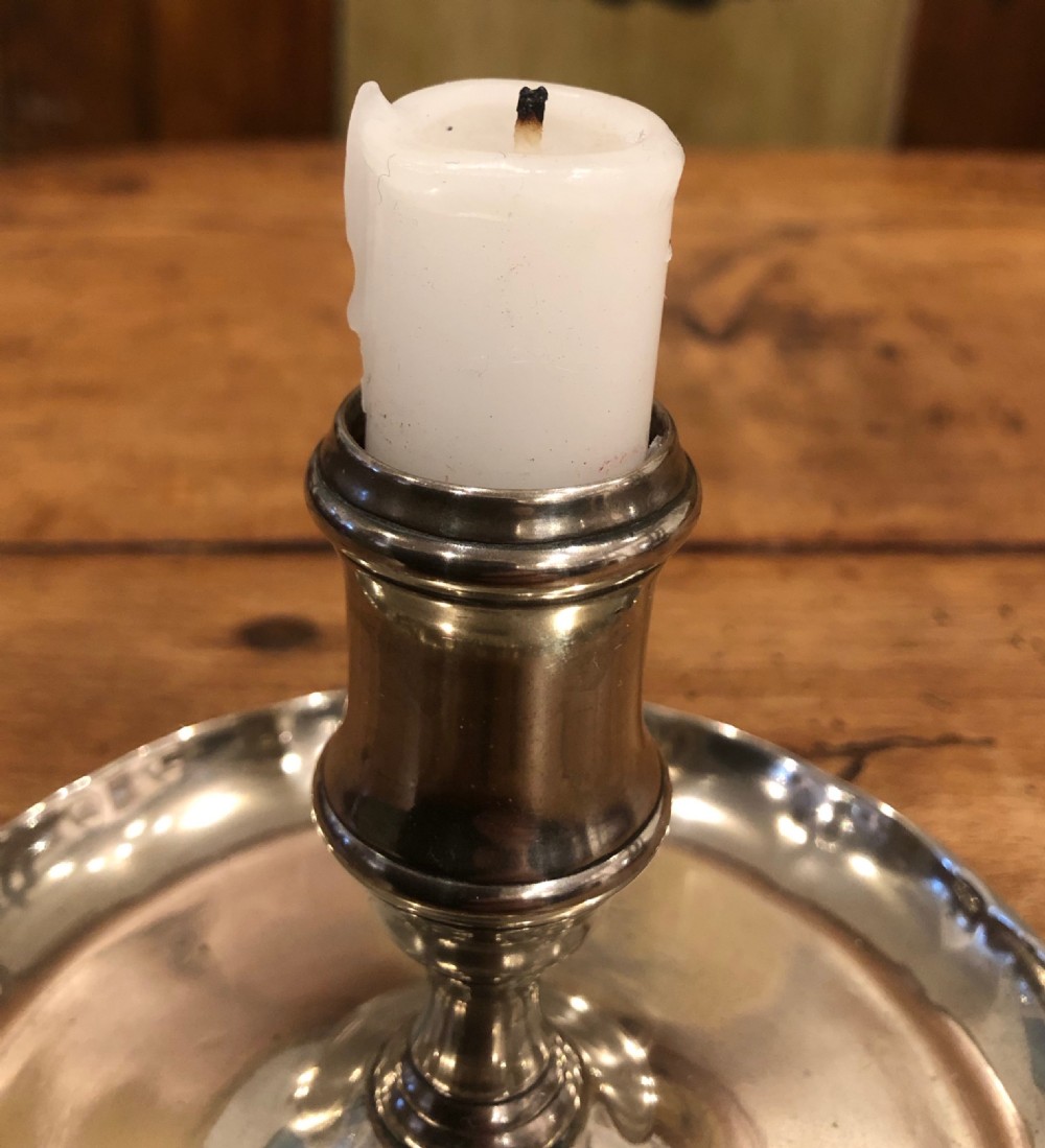 An 18th-century silver-toned paktong chamber candlestick featuring a central tapered candle socket set on a circular tray with a scalloped edge. View II