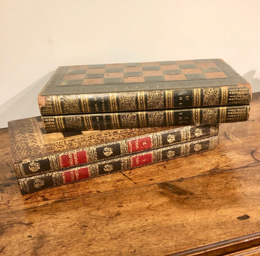 Two late nineteenth-century folding games boards fashioned as double-volume leather-bound books with gilt-tooled spines and chessboard playing tops.