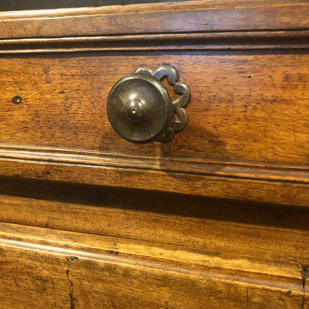 An 18th-century French provincial walnut buffet cabinet featuring a wide top drawer over two carved panelled doors with iron escutcheons and a shaped apron. View IV