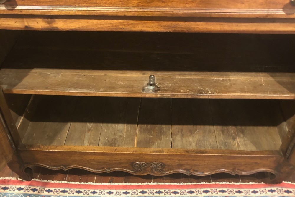 An 18th-century French provincial walnut buffet cabinet featuring a wide top drawer over two carved panelled doors with iron escutcheons and a shaped apron. View VIII