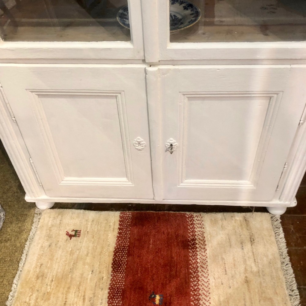 An off-white painted 19th-century French display cabinet featuring arched glazed upper doors, panelled lower cupboard doors, and turned feet. View VII