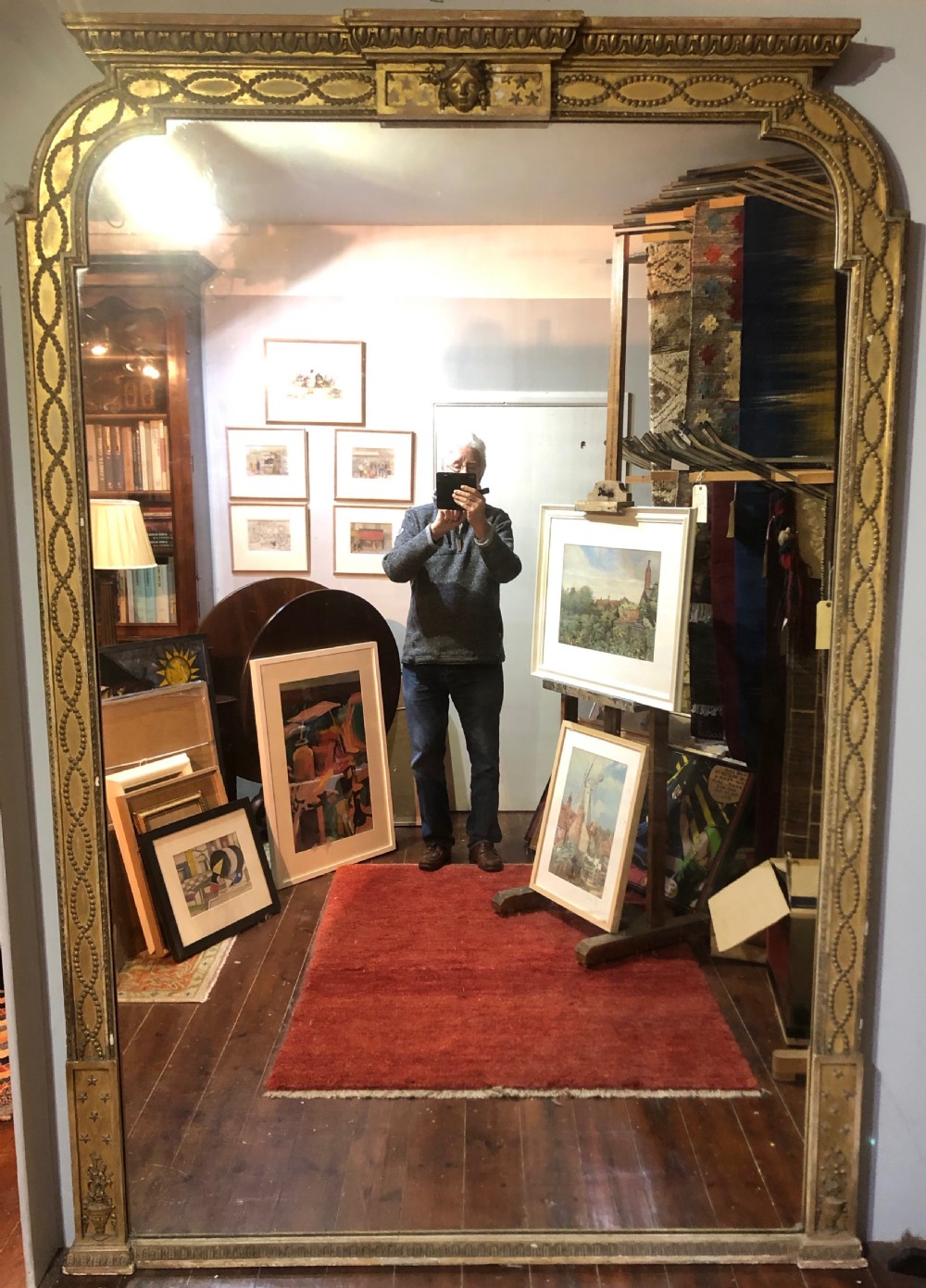 A large Adam Revival giltwood wall mirror featuring an arched top, classical moulding, and guilloche carving.