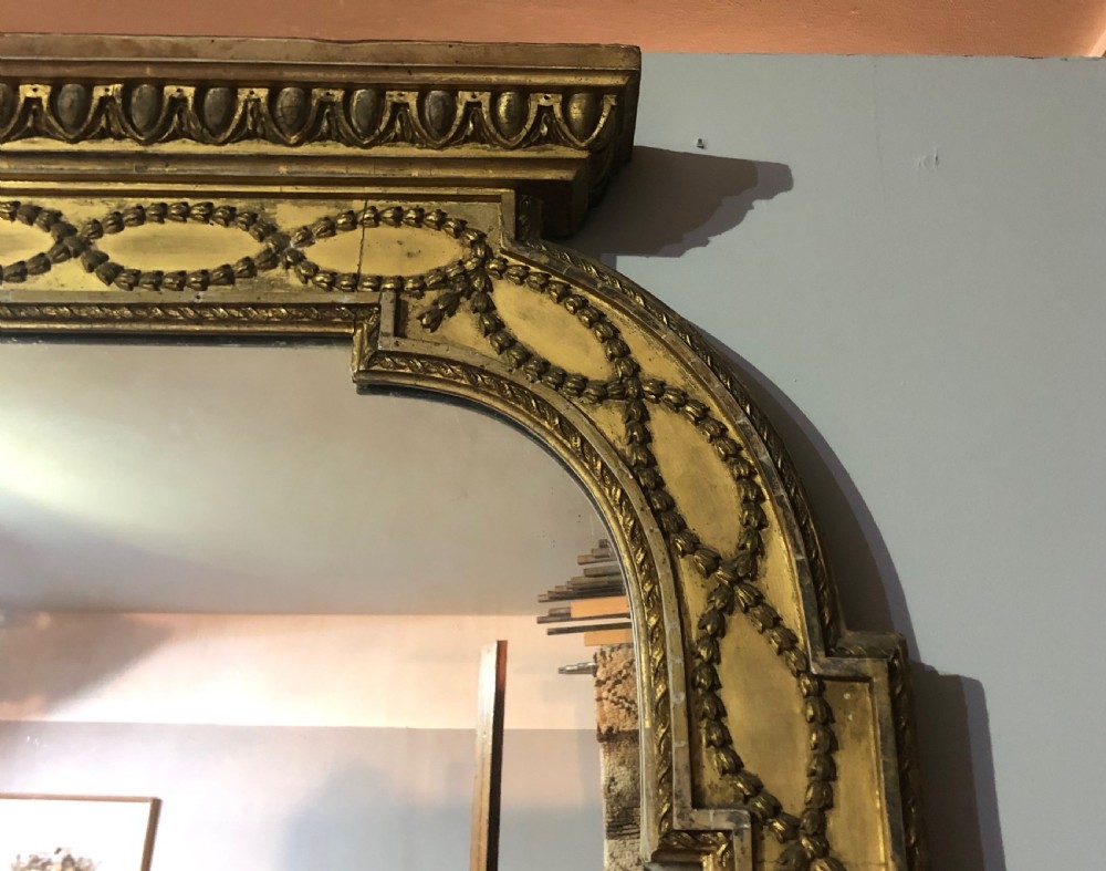 A large Adam Revival giltwood wall mirror featuring an arched top, classical moulding, and guilloche carving. View III