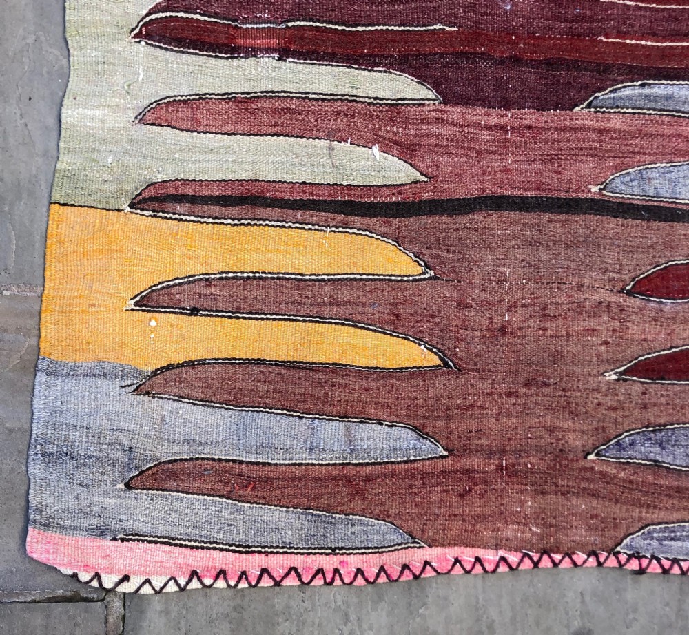 A flatwoven Turkish Afyon kelim rug featuring a central finger motif in shades of terracotta, maroon, grey, orange, and yellow. View V