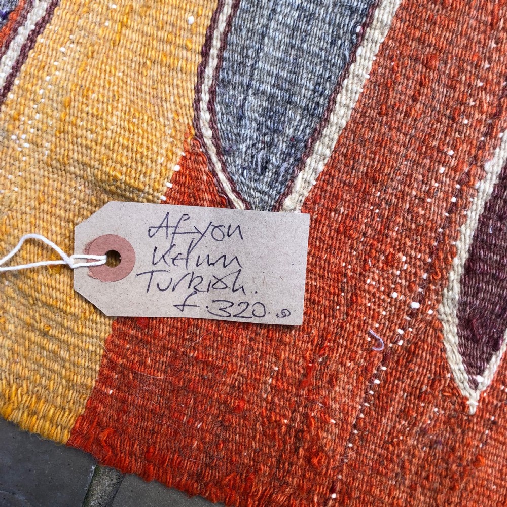 A flatwoven Turkish Afyon kelim rug featuring a central finger motif in shades of terracotta, maroon, grey, orange, and yellow. View VI