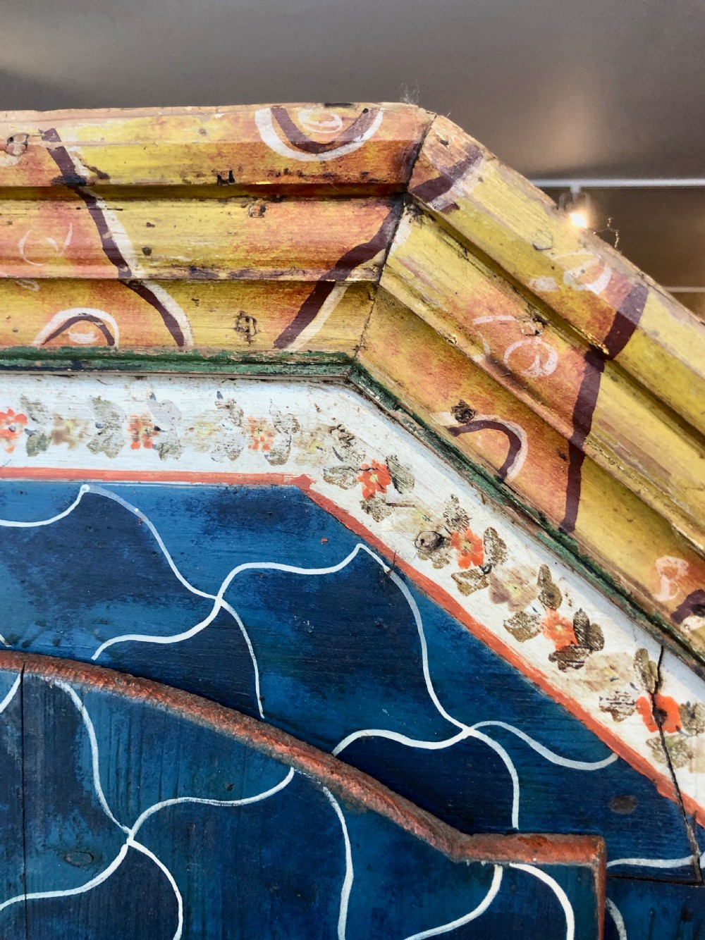 An Austro-Hungarian painted pine marriage armoire featuring a blue ground with geometric lattice motifs, hand-painted floral panels, and a shaped top cornice. View VII