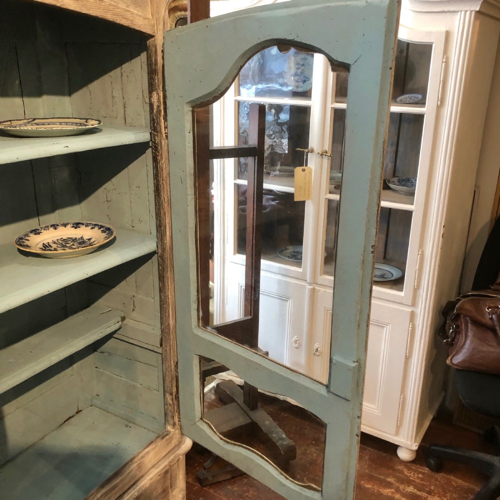 An 18th-century French limed oak vitrine featuring two glazed doors with curved frames, two lower drawers, carved floral detailing, and short cabriole feet. View II