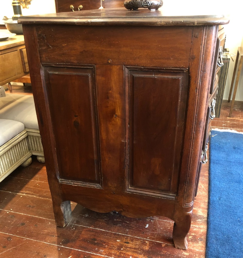 An 18th-century French walnut commode featuring a serpentine front, three drawers with carved moulded frames, cast brass handles, and cabriole legs. View V