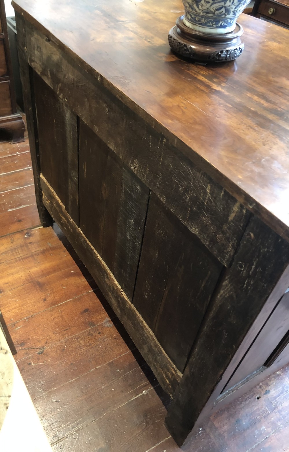 An 18th-century French walnut commode featuring a serpentine front, three drawers with carved moulded frames, cast brass handles, and cabriole legs. View VI
