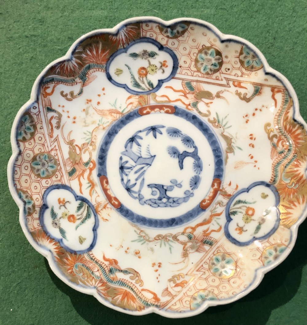 An 18th-century Chinese Imari porcelain dish featuring a lobed scalloped edge, underglaze blue floral roundel, and overglaze iron-red and gilded reserve panels.