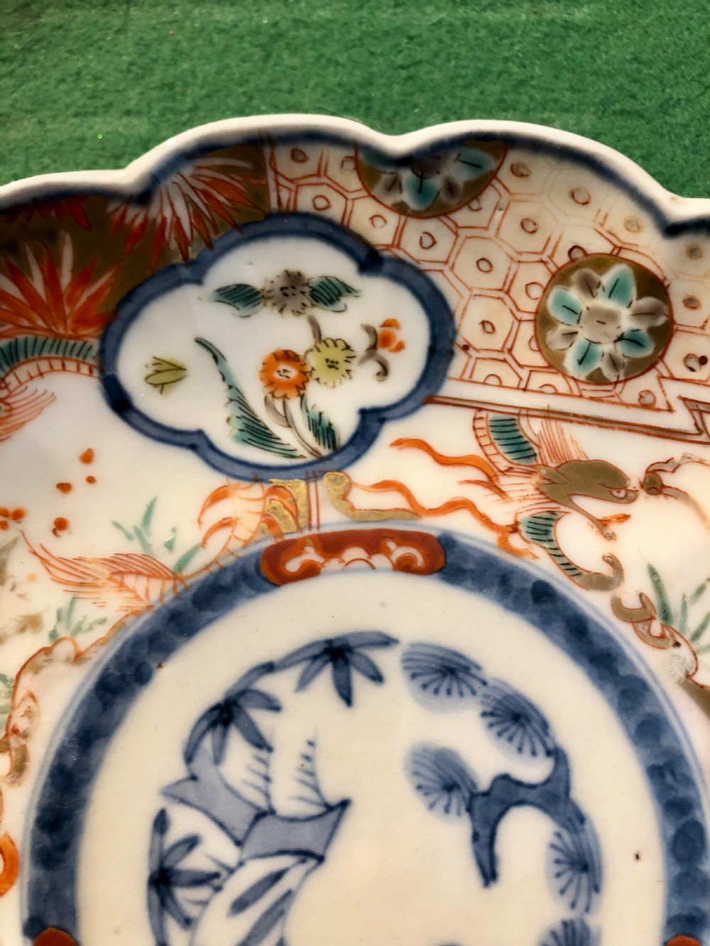 An 18th-century Chinese Imari porcelain dish featuring a lobed scalloped edge, underglaze blue floral roundel, and overglaze iron-red and gilded reserve panels. View II