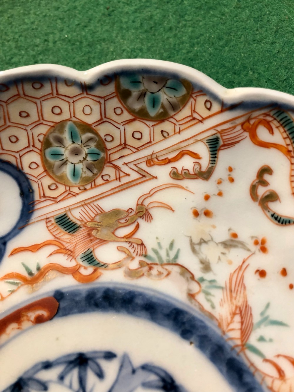 An 18th-century Chinese Imari porcelain dish featuring a lobed scalloped edge, underglaze blue floral roundel, and overglaze iron-red and gilded reserve panels. View III