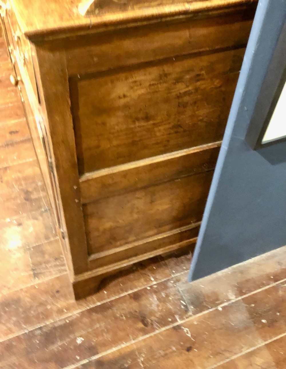 An 18th-century English elm dresser with a three-shelf plate rack, lower drawers with brass handles, and two panelled cupboard doors. View IV