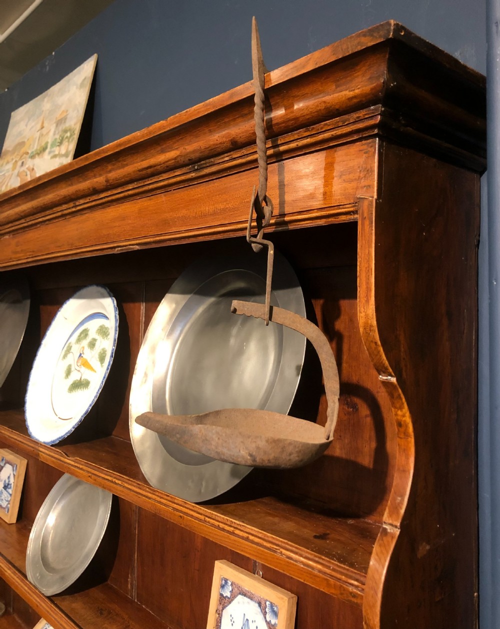 An 18th-century English elm dresser with a three-shelf plate rack, lower drawers with brass handles, and two panelled cupboard doors. View VI