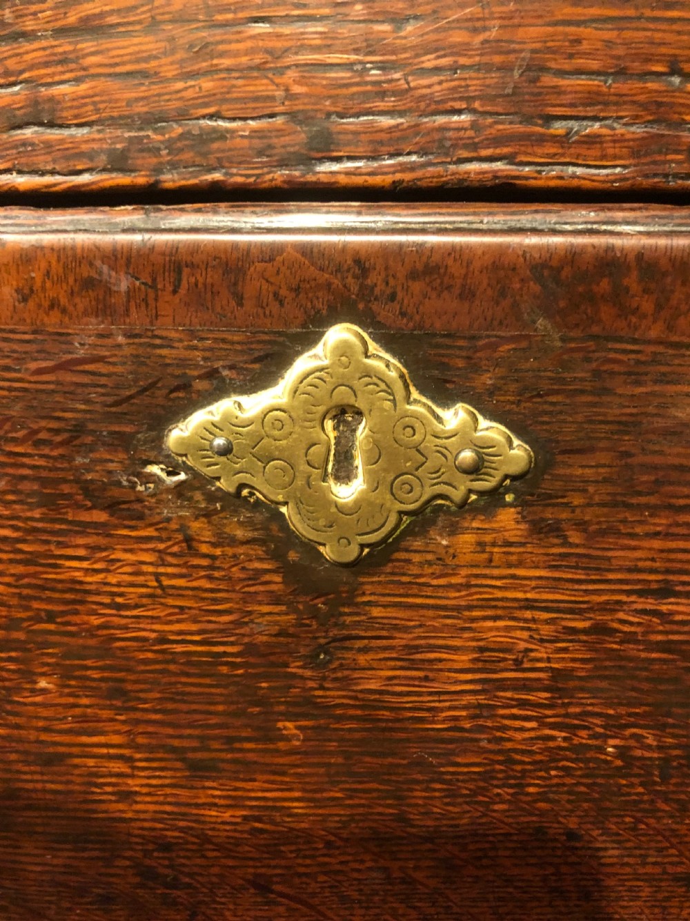 An 18th-century dark oak dresser base featuring three brass-handled drawers supported on slender cabriole legs. View VI