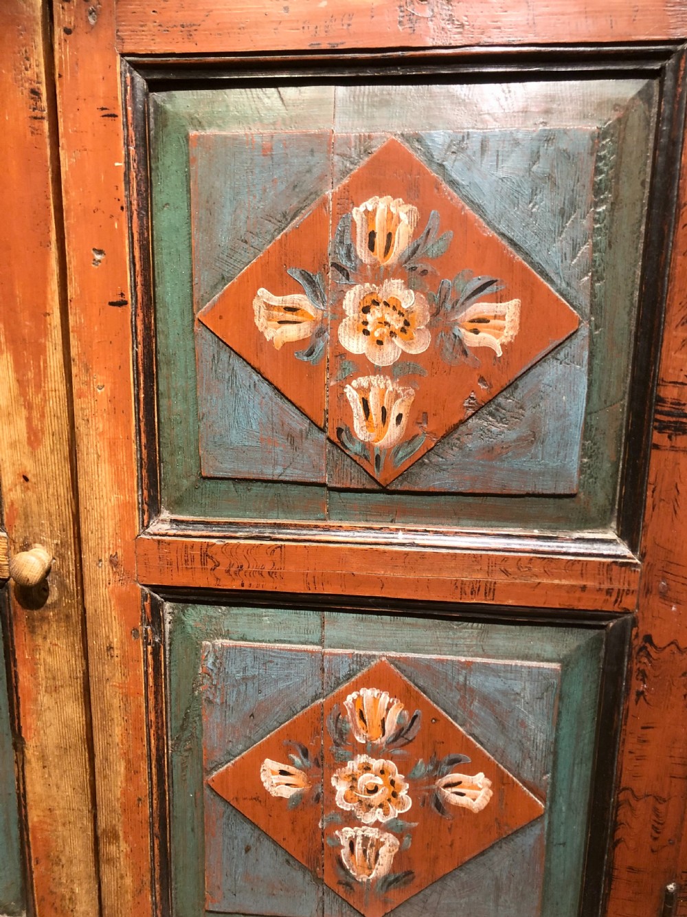A 19th-century Austro-Hungarian two-tier wooden cupboard decorated with hand-painted floral panels in terracotta red, cream, and teal blue tones. View IV