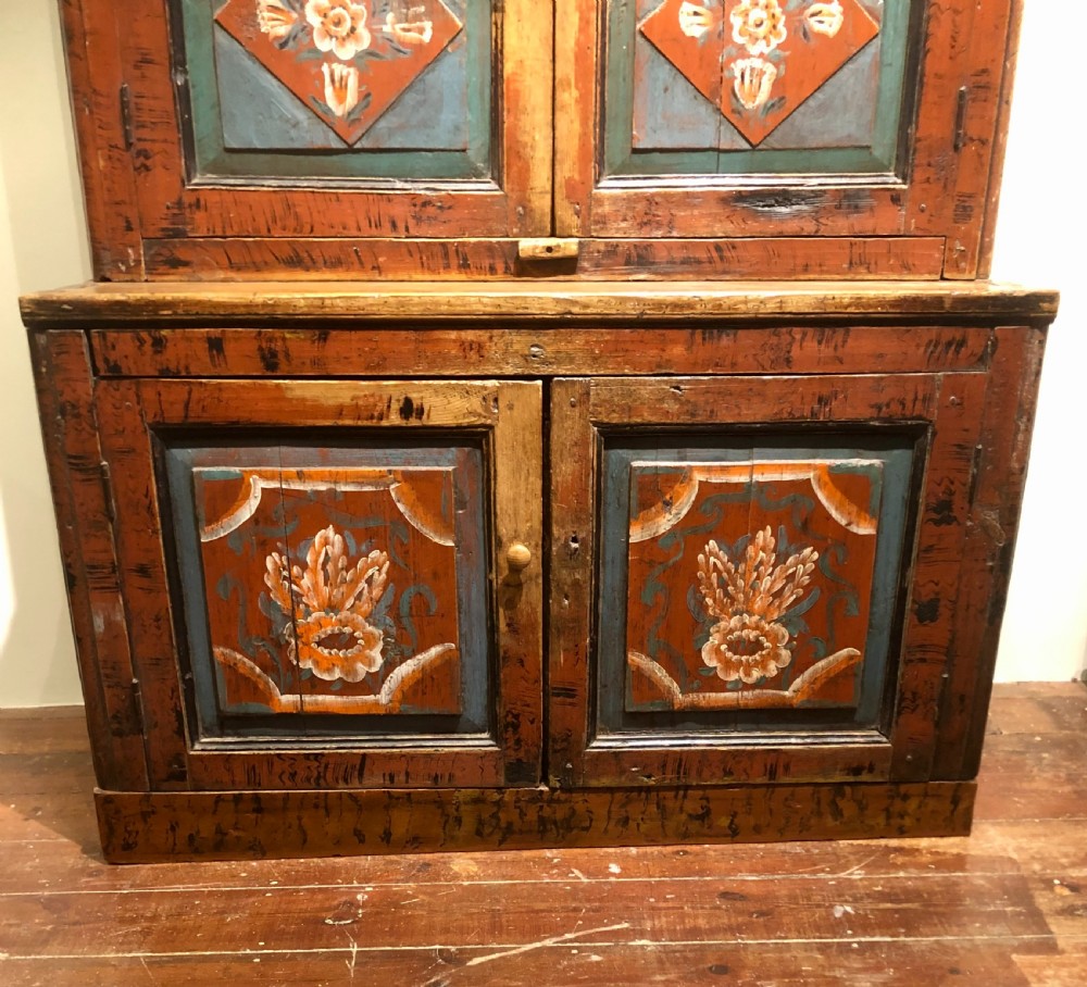 A 19th-century Austro-Hungarian two-tier wooden cupboard decorated with hand-painted floral panels in terracotta red, cream, and teal blue tones. View VI