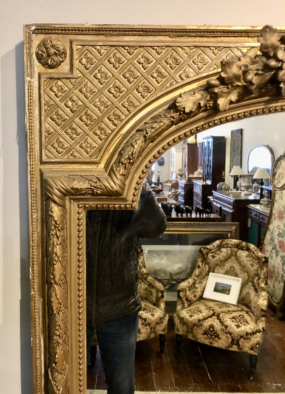 A large rectangular French giltwood wall mirror featuring an arched inner frame with floral cresting and carved decorative borders. View VI