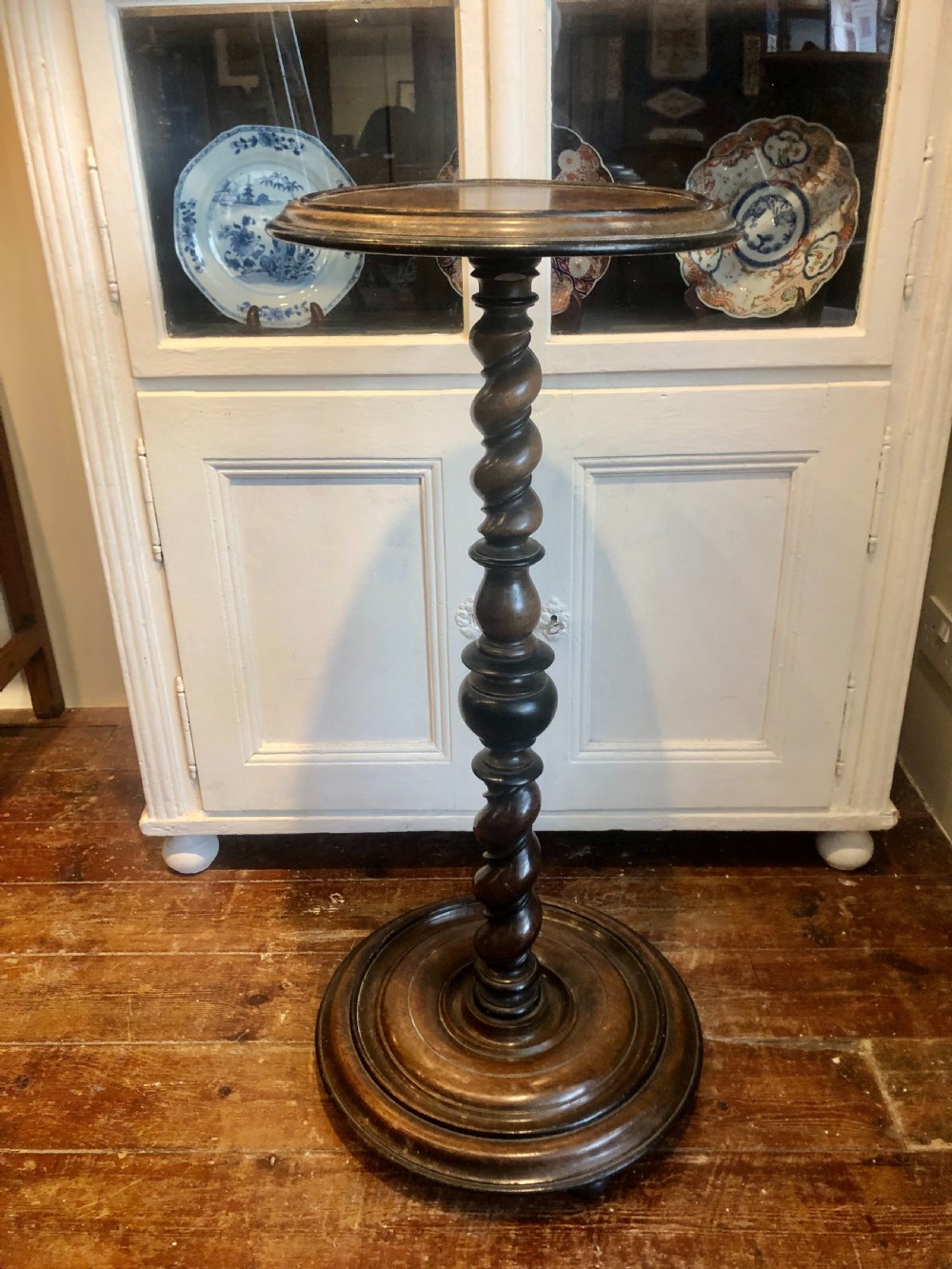 An 18th-century Georgian mahogany pedestal featuring a barley twist column, ebonised turnings, and a heavy circular moulded base.