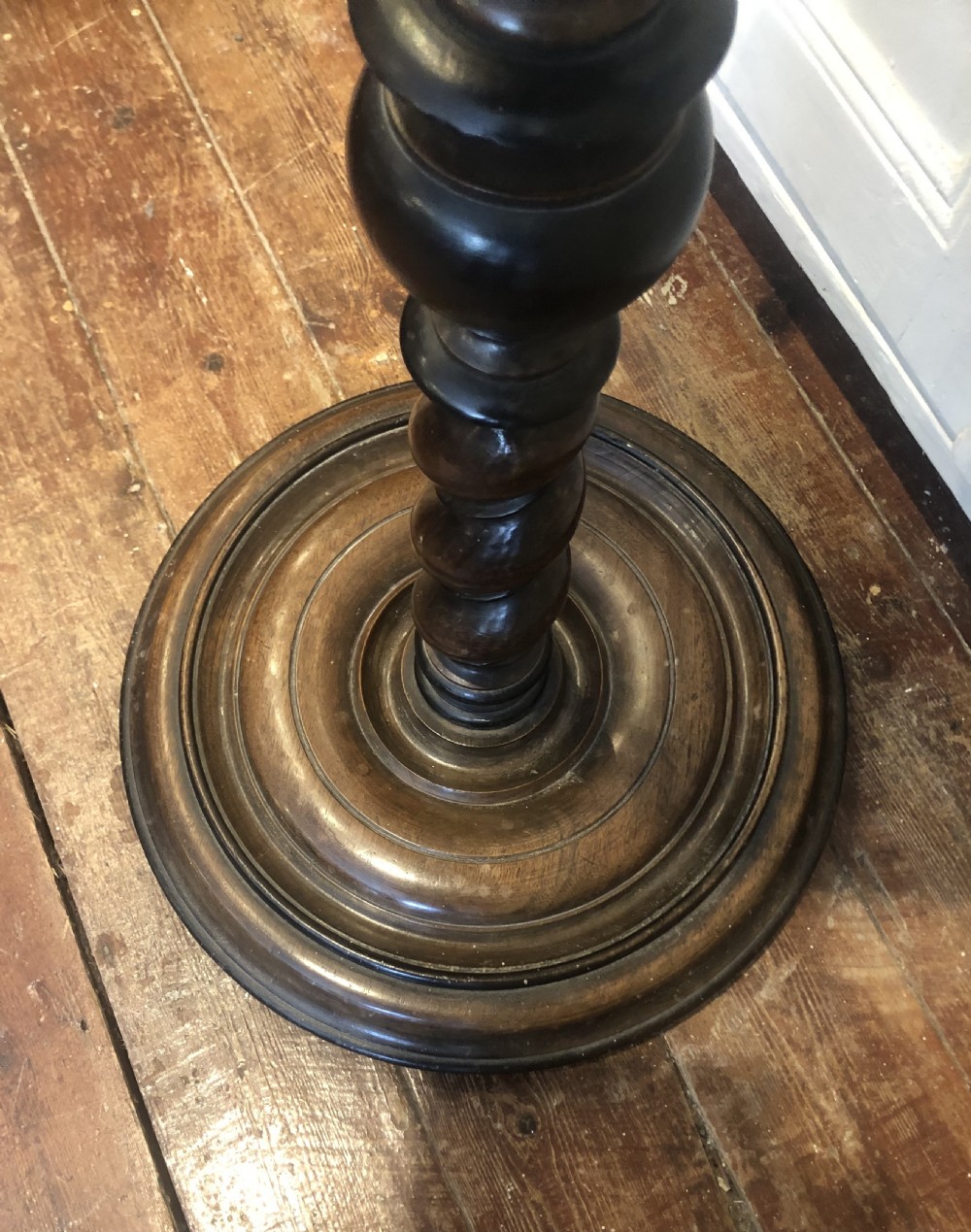 An 18th-century Georgian mahogany pedestal featuring a barley twist column, ebonised turnings, and a heavy circular moulded base. View V