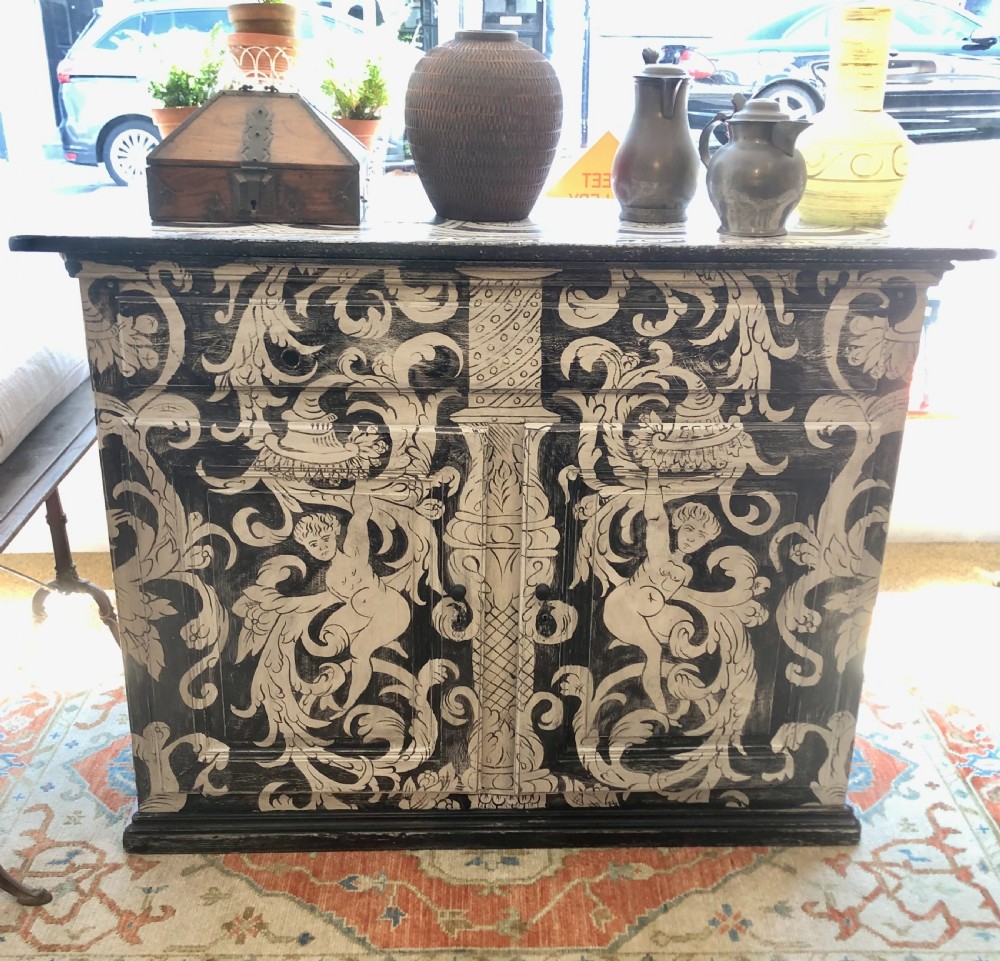 A two-door wooden French buffet cabinet hand-painted with black and white grotesque foliate scrollwork and human figures. View II