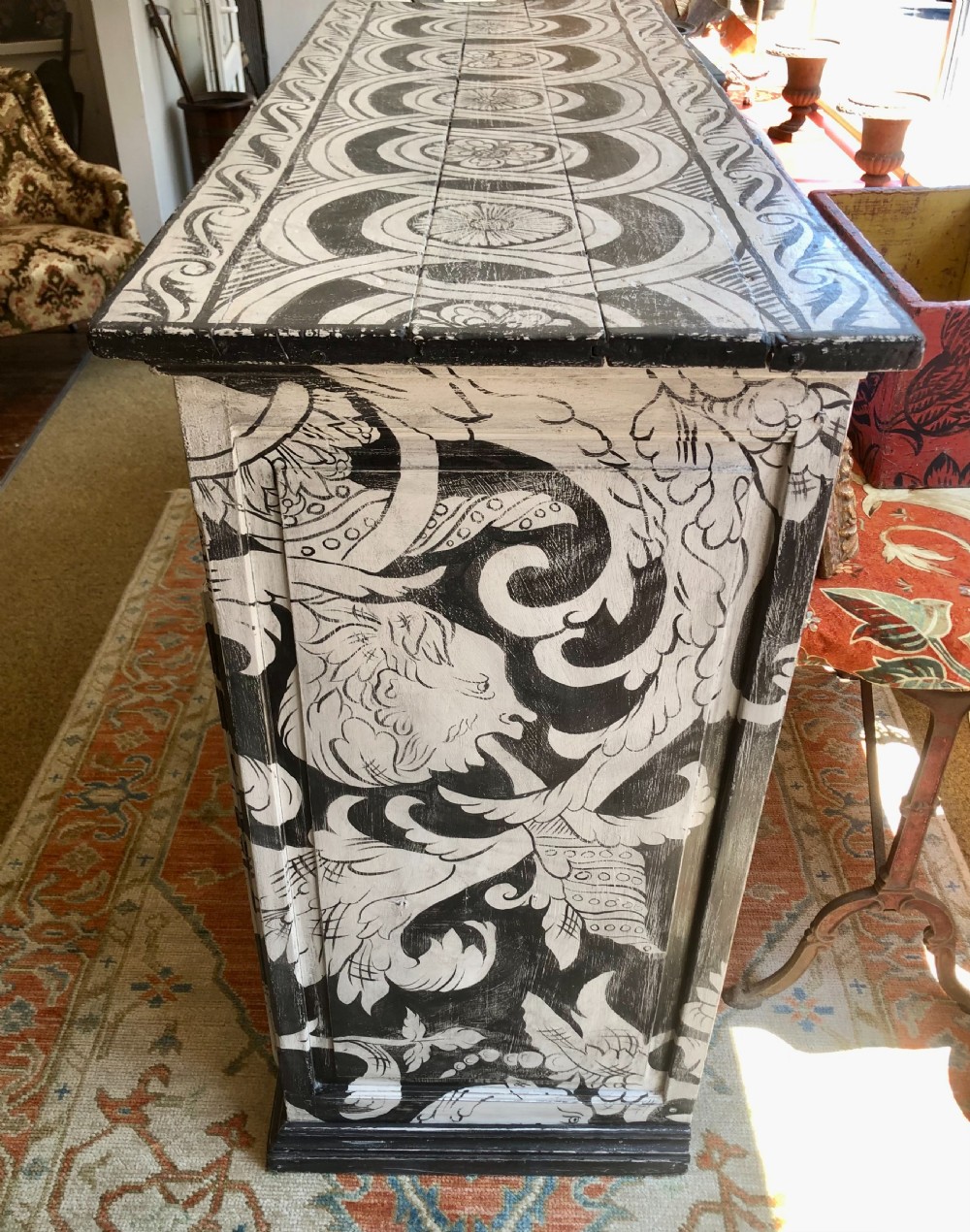 A two-door wooden French buffet cabinet hand-painted with black and white grotesque foliate scrollwork and human figures. View IV