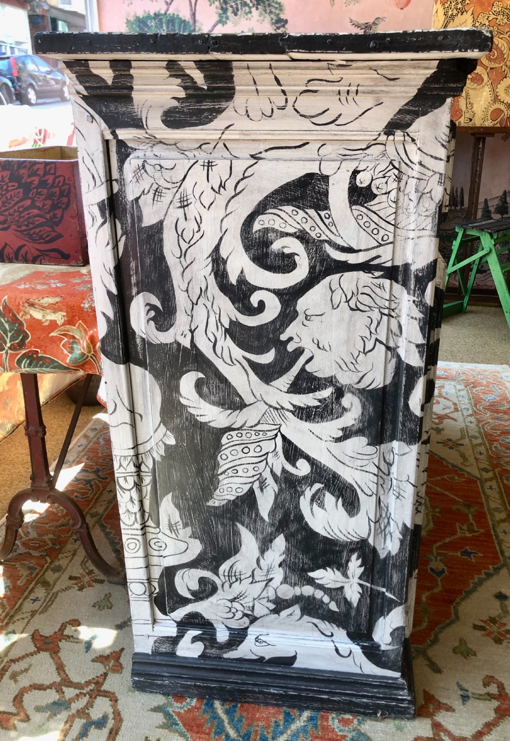 A two-door wooden French buffet cabinet hand-painted with black and white grotesque foliate scrollwork and human figures. View VI
