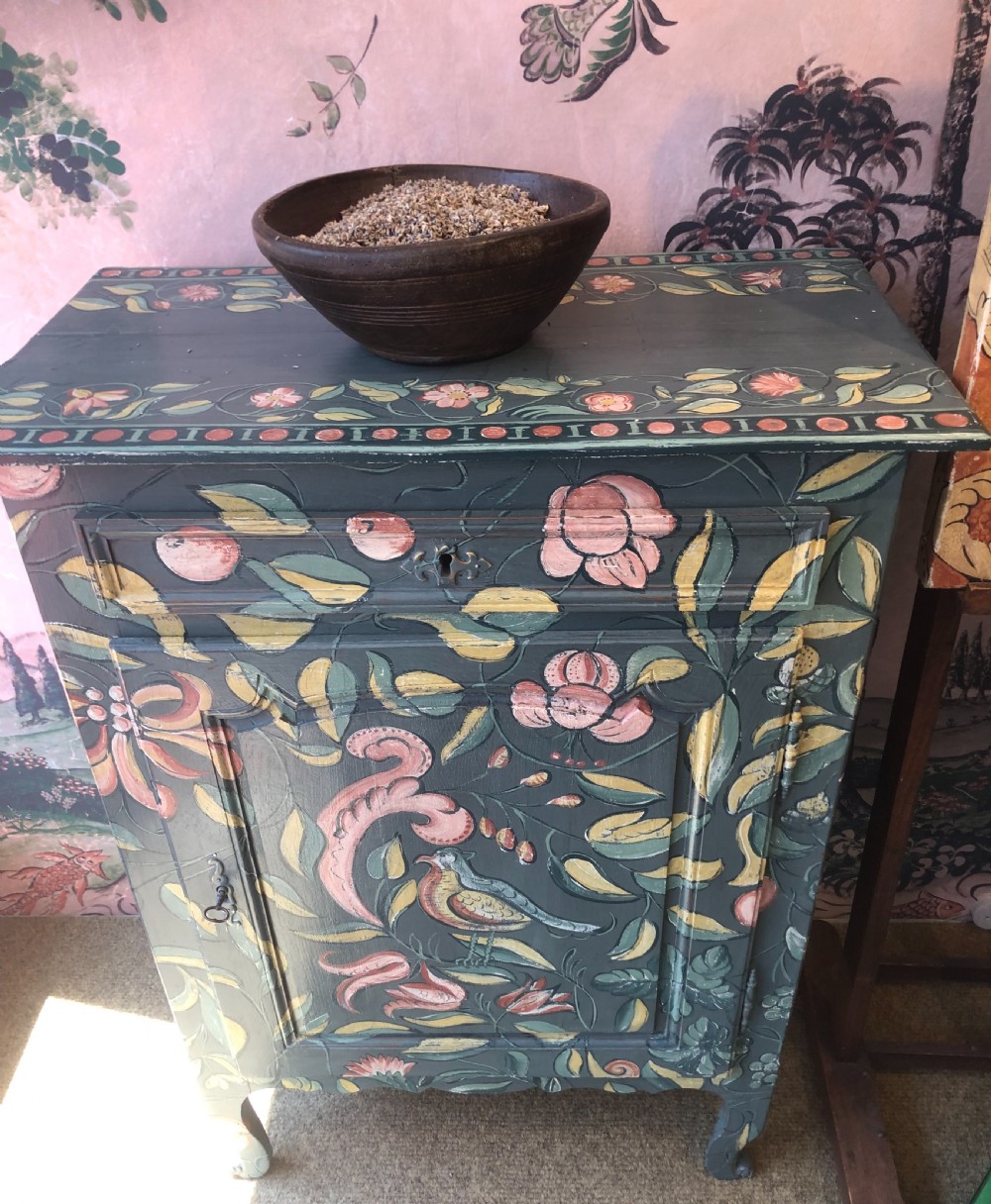 A hand-painted dark green French single-door wooden cupboard decorated with botanical foliage and bird motifs.
