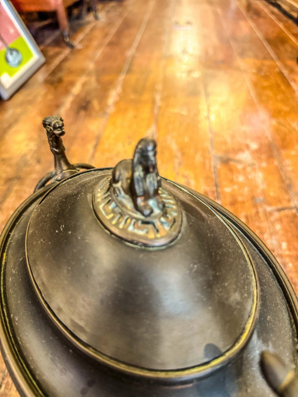 An antique Regency metal tea urn featuring a dome lid with finial, Greek key engraved band, zoomorphic side handles, and a brass spigot on a pedestal base. View III