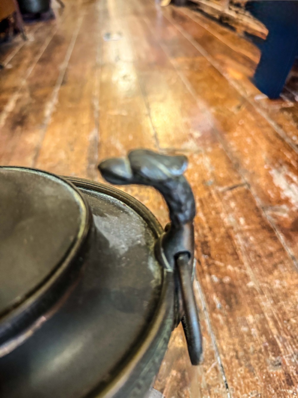 An antique Regency metal tea urn featuring a dome lid with finial, Greek key engraved band, zoomorphic side handles, and a brass spigot on a pedestal base. View IV