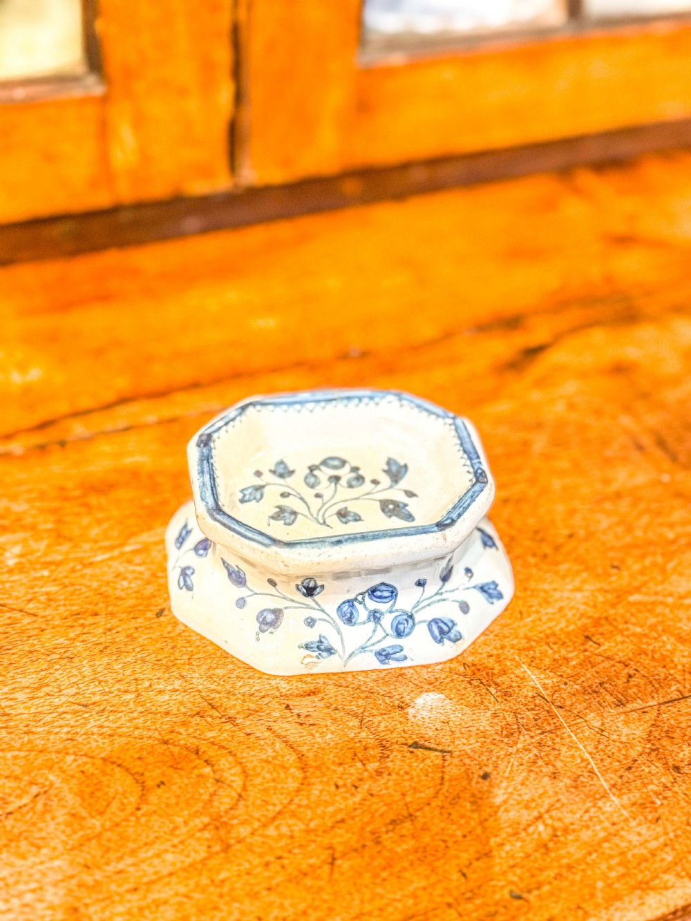 An eighteenth-century octagonal English Delftware salt cellar crafted from tin-glazed earthenware and decorated with hand-painted cobalt blue botanical patterns. View II