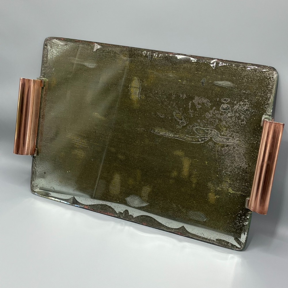 A rectangular Art Deco mirrored glass tray featuring cut decorative edges and rolled copper handles supported by small footings. View II