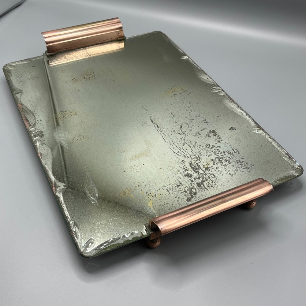 A rectangular Art Deco mirrored glass tray featuring cut decorative edges and rolled copper handles supported by small footings. View IV