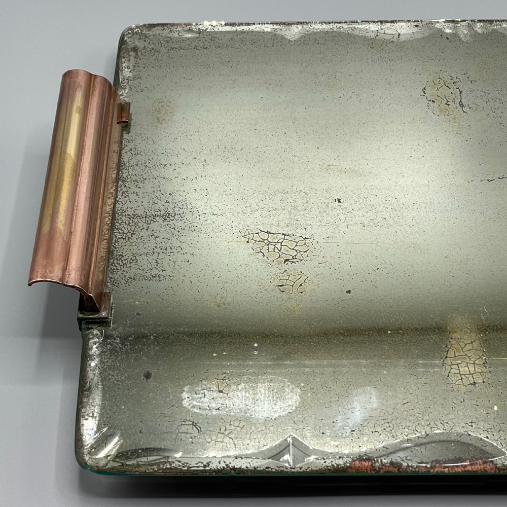 A rectangular Art Deco mirrored glass tray featuring cut decorative edges and rolled copper handles supported by small footings. View VII