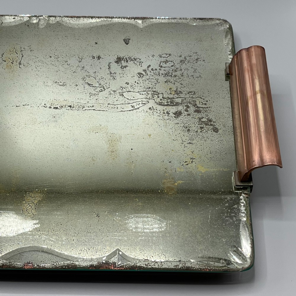 A rectangular Art Deco mirrored glass tray featuring cut decorative edges and rolled copper handles supported by small footings. View IX