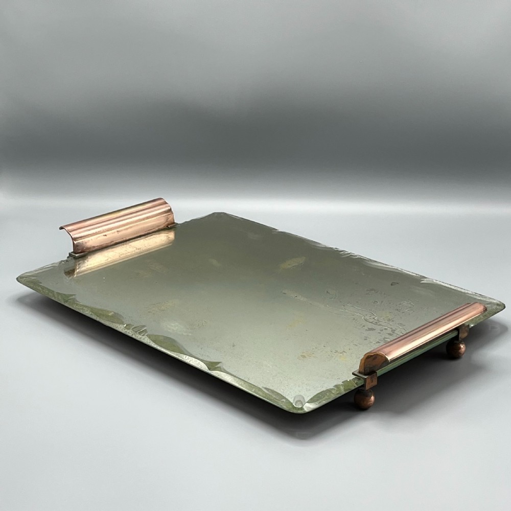 A rectangular Art Deco mirrored glass tray featuring cut decorative edges and rolled copper handles supported by small footings. View X