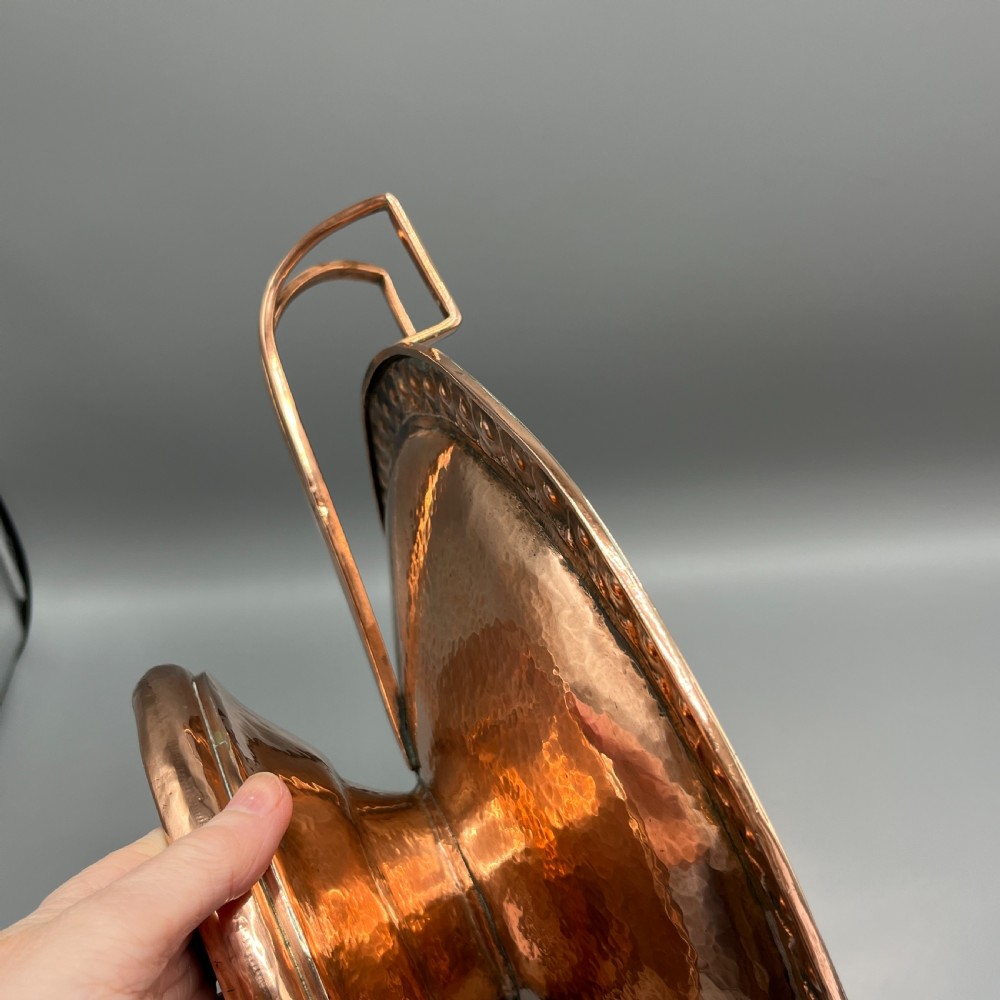 A hand-hammered copper tazza featuring twin side handles, a circular pedestal base, and a stamped geometric border along the shallow bowl rim. View XVI