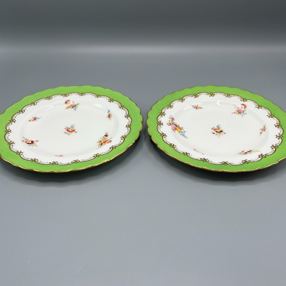 A pair of Victorian Coalport porcelain plates with bright green scalloped borders, gilded scrollwork, and hand-painted floral sprays on white centres. View III