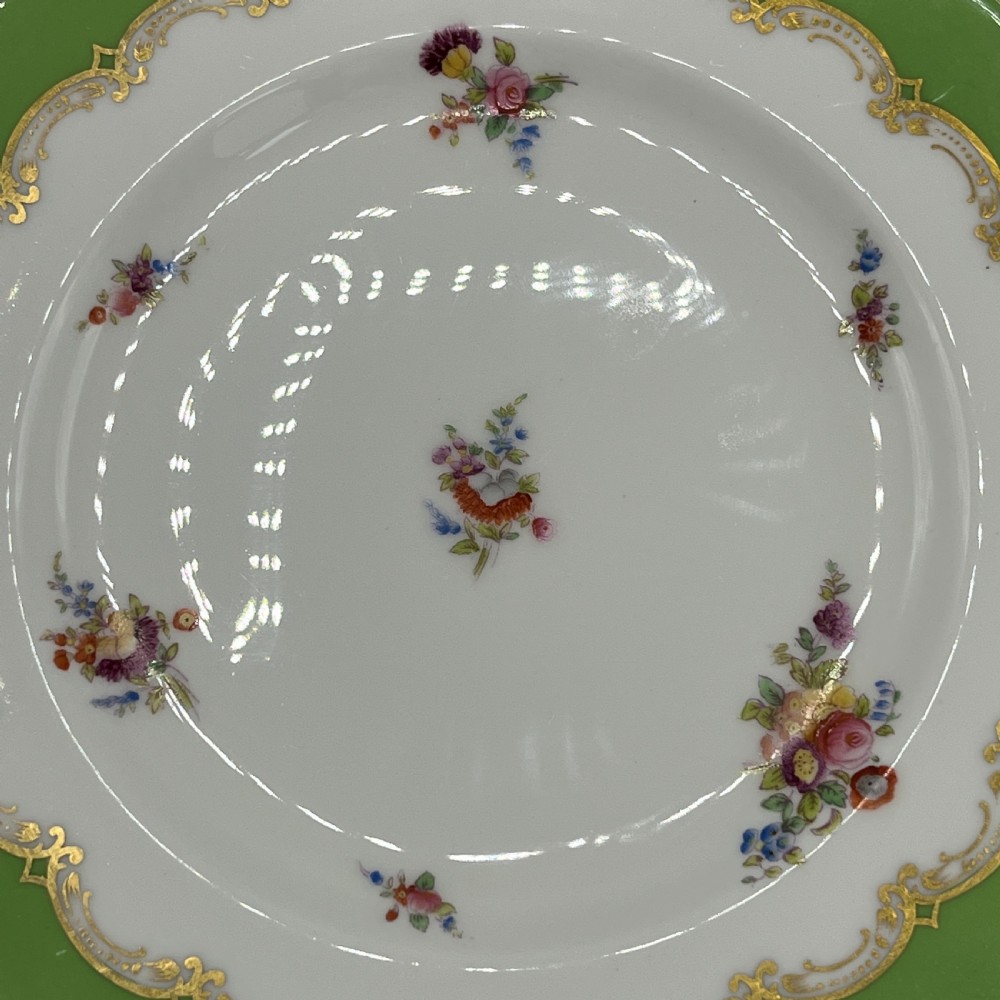 A pair of Victorian Coalport porcelain plates with bright green scalloped borders, gilded scrollwork, and hand-painted floral sprays on white centres. View XI