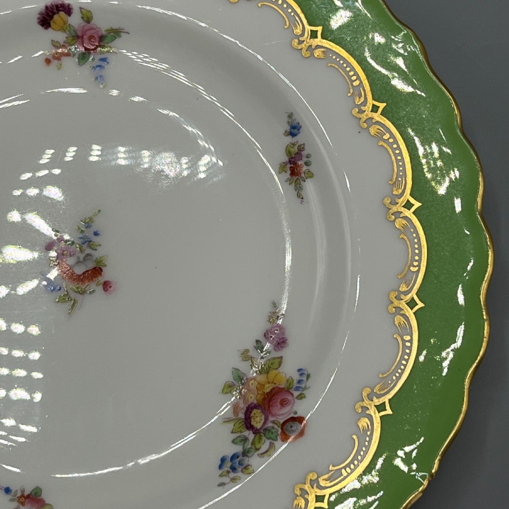 A pair of Victorian Coalport porcelain plates with bright green scalloped borders, gilded scrollwork, and hand-painted floral sprays on white centres. View XIII