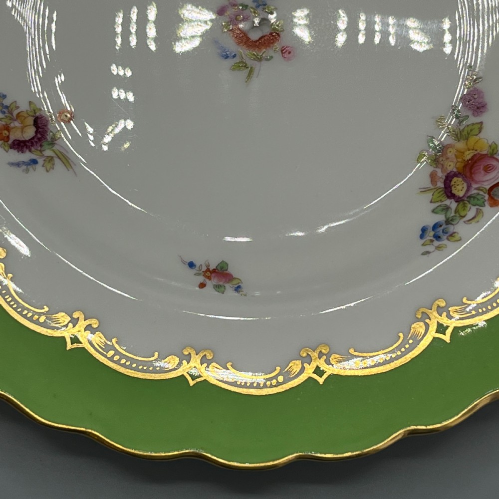 A pair of Victorian Coalport porcelain plates with bright green scalloped borders, gilded scrollwork, and hand-painted floral sprays on white centres. View XIV