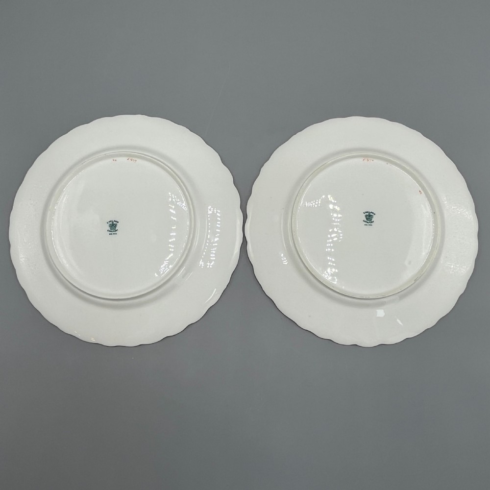 A pair of Victorian Coalport porcelain plates with bright green scalloped borders, gilded scrollwork, and hand-painted floral sprays on white centres. View XV